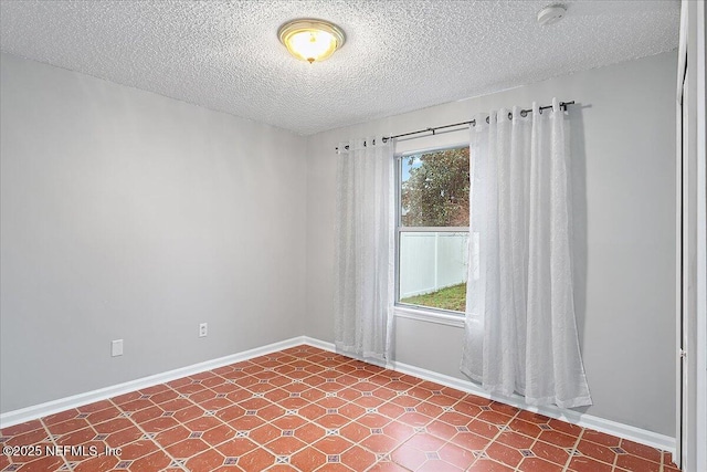 spare room with a textured ceiling and plenty of natural light