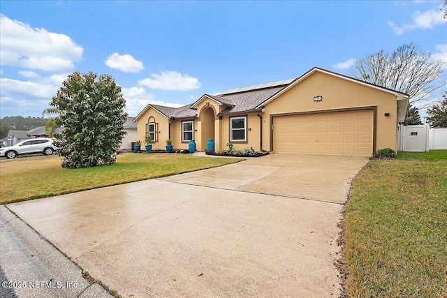 ranch-style home with solar panels, a front lawn, and a garage