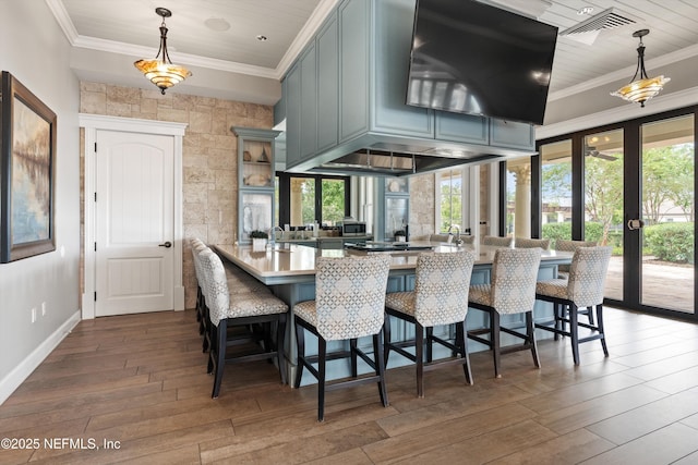 kitchen with a breakfast bar, dark hardwood / wood-style floors, kitchen peninsula, and hanging light fixtures