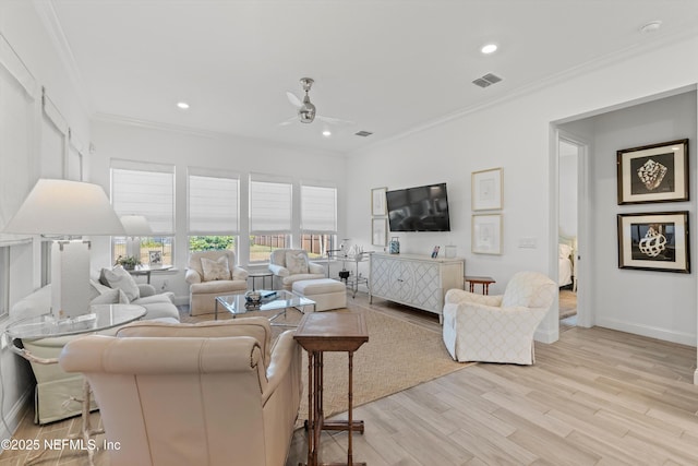 living room with light hardwood / wood-style floors, ceiling fan, and ornamental molding