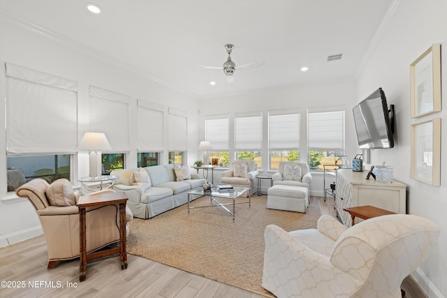 living room featuring ceiling fan, ornamental molding, and light hardwood / wood-style flooring