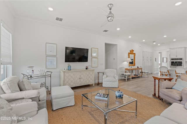 living room featuring light hardwood / wood-style floors, ceiling fan, and ornamental molding