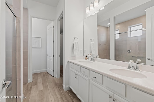 bathroom featuring a shower with door, vanity, and hardwood / wood-style flooring