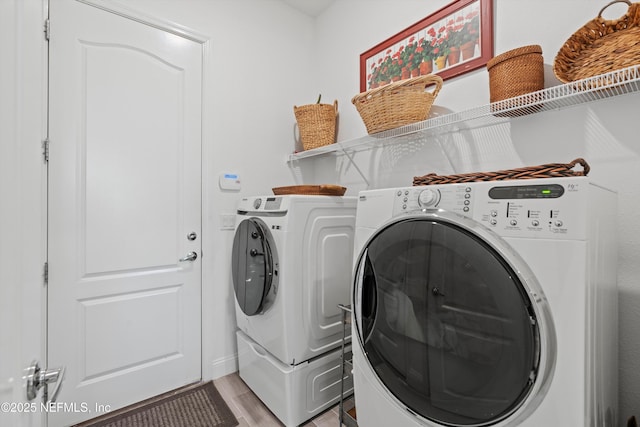 clothes washing area featuring light hardwood / wood-style floors and washing machine and dryer