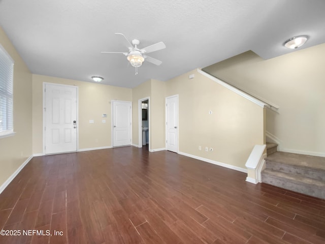 unfurnished living room with dark hardwood / wood-style floors and ceiling fan