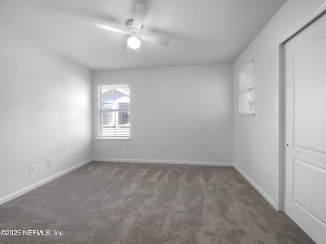 carpeted spare room featuring ceiling fan and a textured ceiling