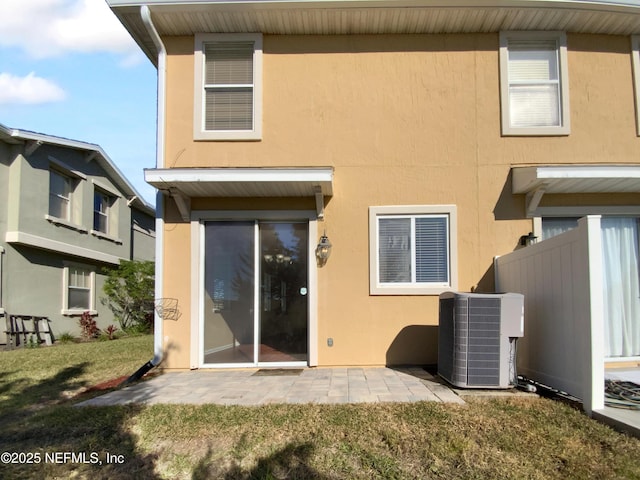 back of house featuring a lawn and central air condition unit