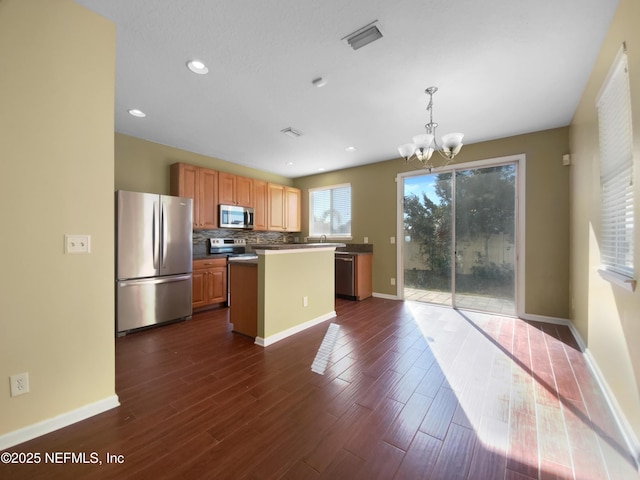 kitchen featuring a center island, dark hardwood / wood-style floors, decorative light fixtures, stainless steel appliances, and a chandelier