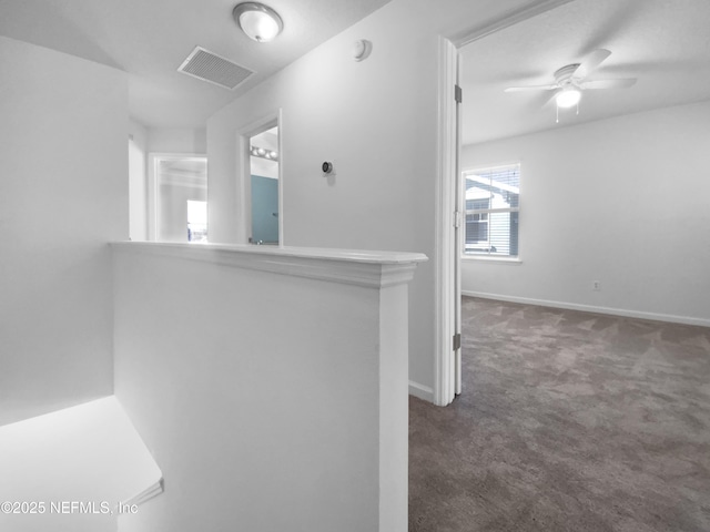 hall featuring dark colored carpet