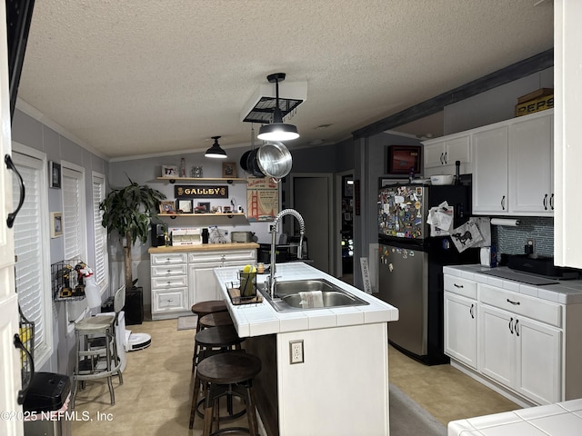 kitchen with decorative light fixtures, tile countertops, white cabinetry, and sink