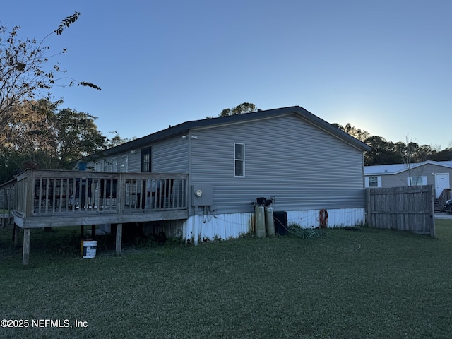 back of property featuring a yard and a wooden deck