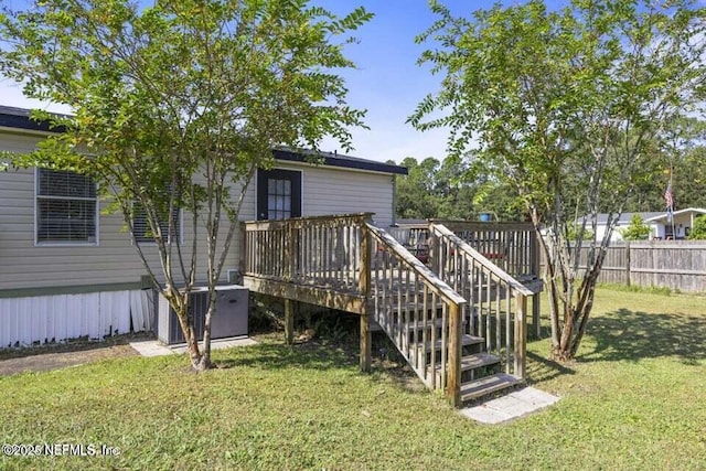 back of property featuring a lawn, cooling unit, and a wooden deck