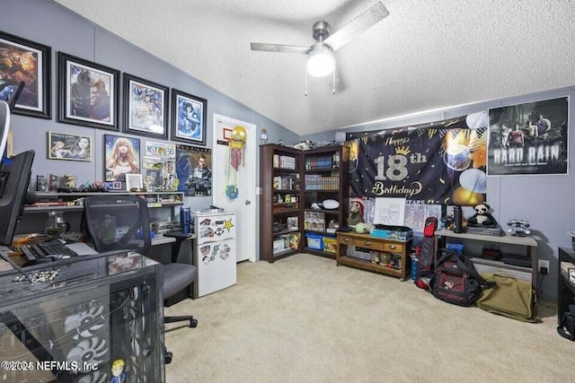 office area with vaulted ceiling, ceiling fan, light colored carpet, and a textured ceiling