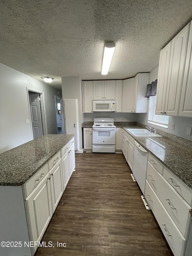 kitchen with dark stone counters, a textured ceiling, white appliances, sink, and white cabinets