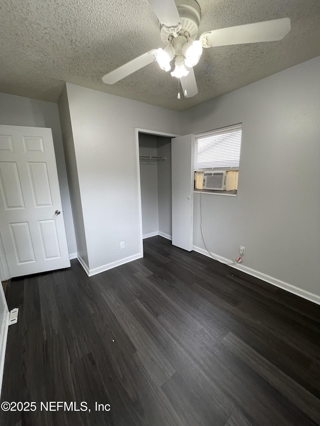 unfurnished bedroom with a closet, ceiling fan, dark hardwood / wood-style flooring, and a textured ceiling