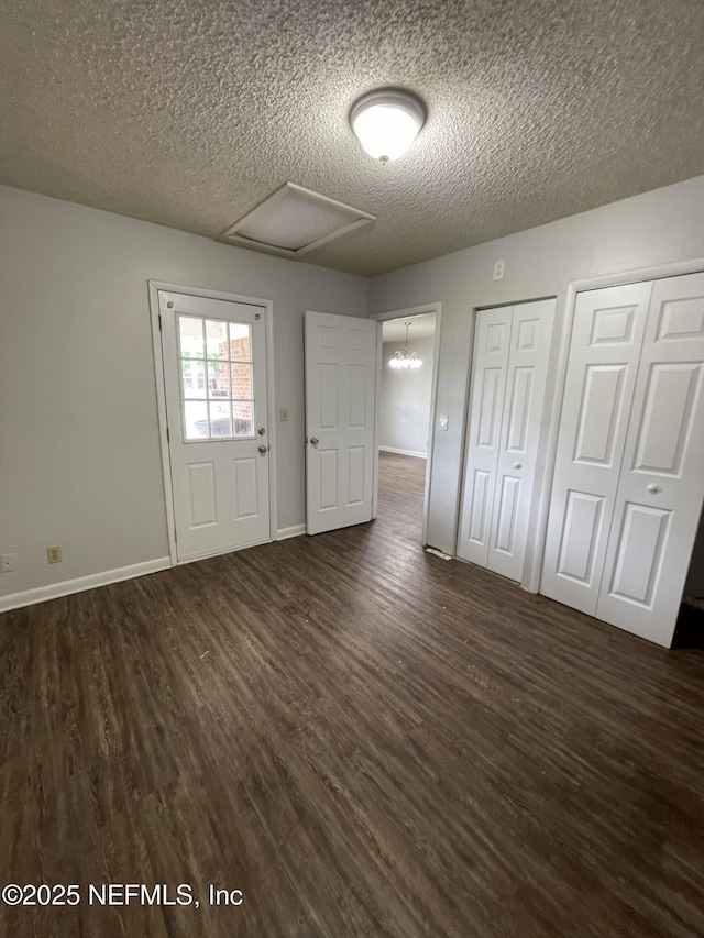 entryway with a notable chandelier, dark hardwood / wood-style floors, and a textured ceiling