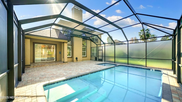 view of pool with glass enclosure and a patio