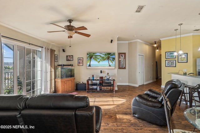 living room with ornamental molding, dark hardwood / wood-style floors, and ceiling fan