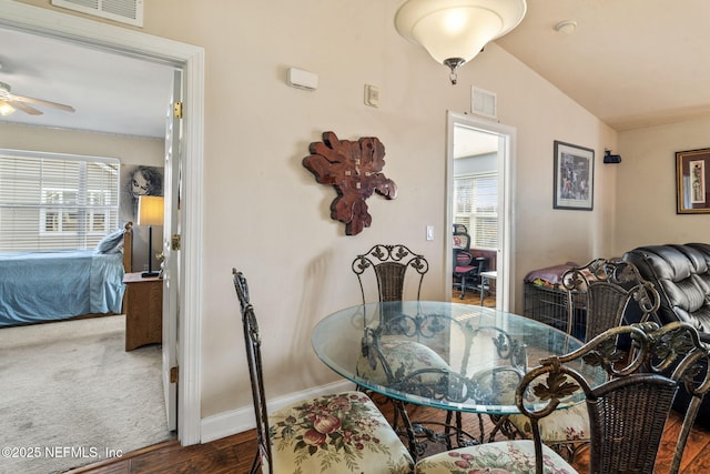 dining space with dark wood-type flooring, ceiling fan, and lofted ceiling