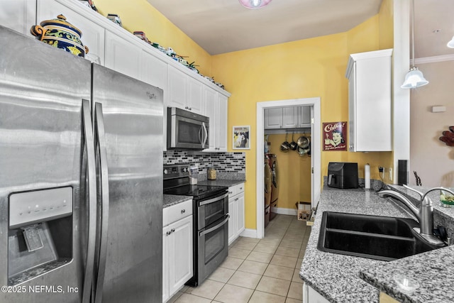 kitchen featuring appliances with stainless steel finishes, pendant lighting, sink, white cabinets, and backsplash