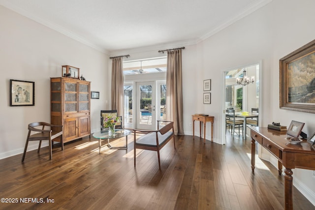 living area with dark wood-type flooring, ornamental molding, a chandelier, and french doors