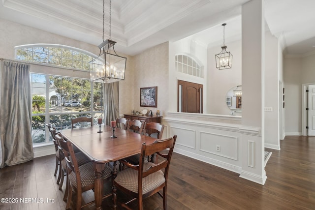 dining area with an inviting chandelier, crown molding, dark hardwood / wood-style flooring, and a raised ceiling