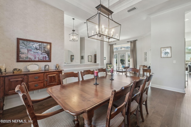 dining space with ornamental molding, a notable chandelier, and dark hardwood / wood-style flooring