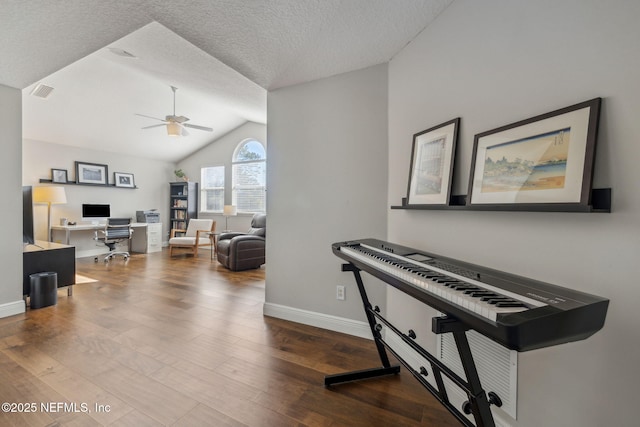 interior space with ceiling fan, wood-type flooring, vaulted ceiling, and a textured ceiling