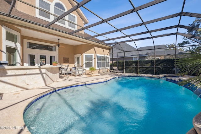 view of swimming pool featuring a patio, pool water feature, a lanai, ceiling fan, and french doors