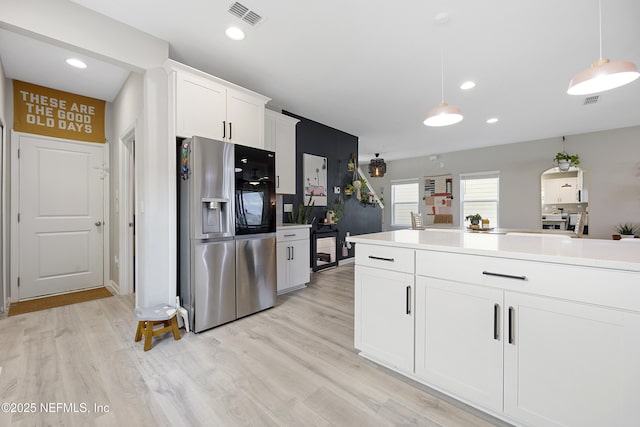 kitchen with white cabinetry, pendant lighting, stainless steel refrigerator with ice dispenser, and light wood-type flooring