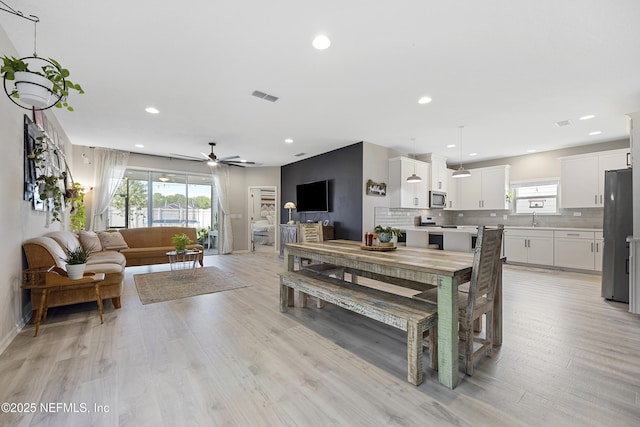 dining room featuring light hardwood / wood-style floors, ceiling fan, and sink