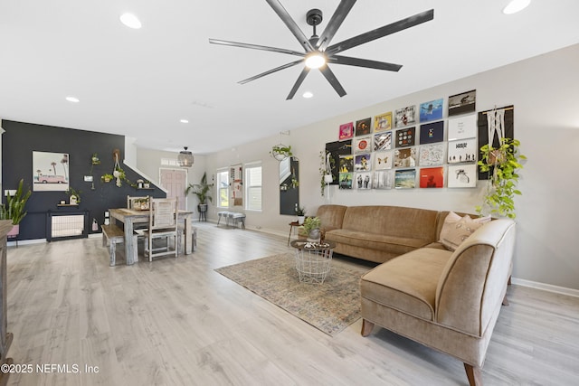 living room featuring ceiling fan and light hardwood / wood-style flooring