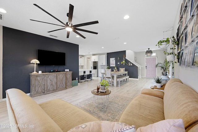 living room with ceiling fan and light hardwood / wood-style floors