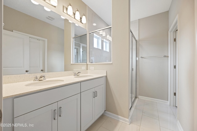 bathroom with tile patterned flooring, vanity, and a shower with door