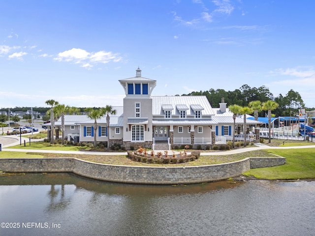 rear view of house featuring a water view and a yard