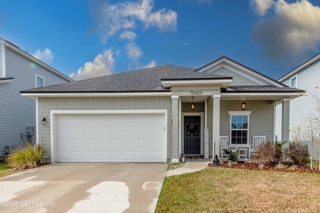 view of front of property featuring a garage, a porch, and a front yard