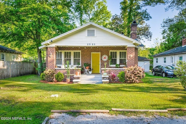 bungalow-style house with covered porch and a front lawn