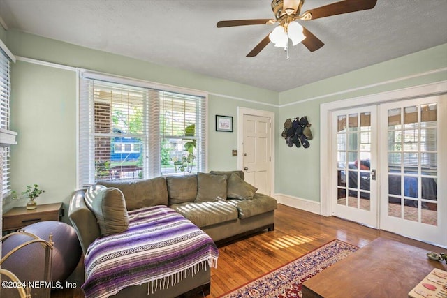 living room featuring french doors, a textured ceiling, ceiling fan, and wood-type flooring