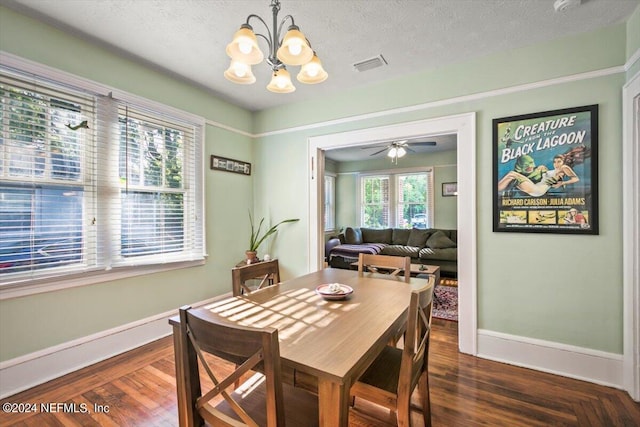 dining area with ceiling fan with notable chandelier, dark hardwood / wood-style flooring, and a textured ceiling