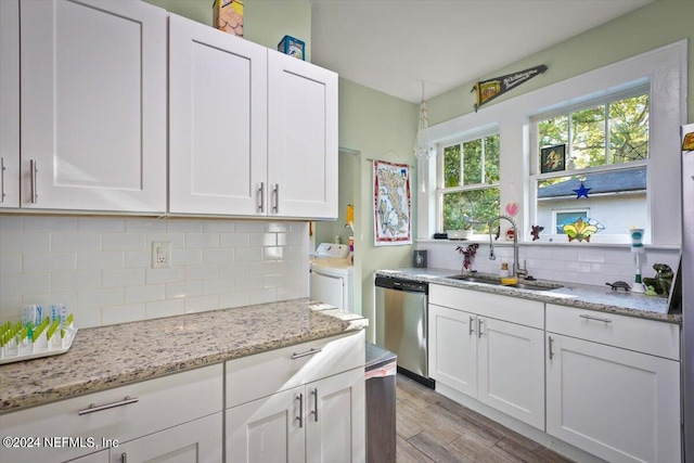 kitchen with sink, white cabinets, stainless steel dishwasher, and light hardwood / wood-style flooring