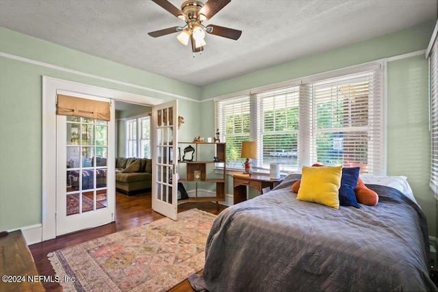 bedroom featuring ceiling fan, french doors, dark wood-type flooring, and multiple windows