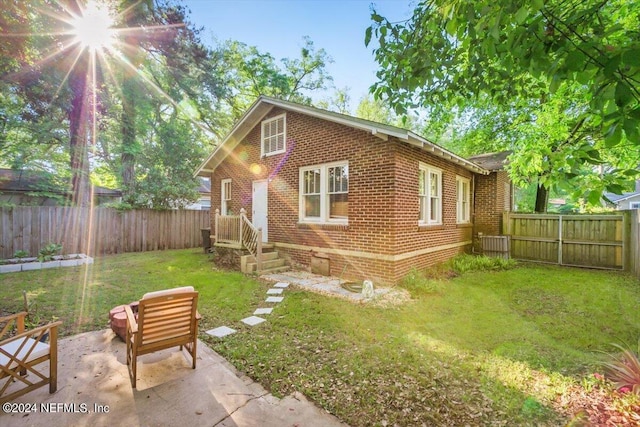 view of front facade featuring a front lawn and a patio