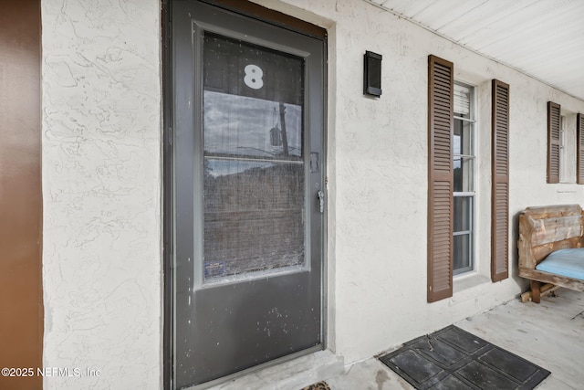 property entrance with stucco siding