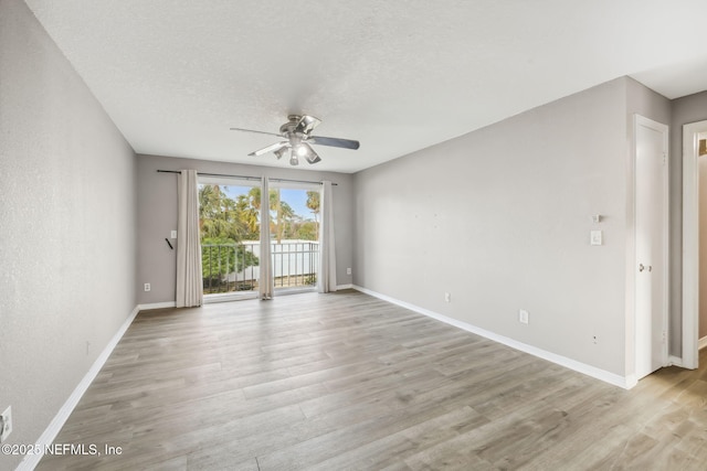 unfurnished room with light wood-style flooring, baseboards, ceiling fan, and a textured ceiling