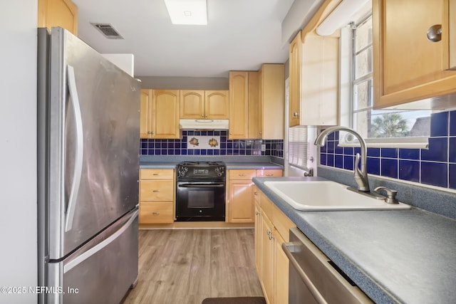 kitchen with decorative backsplash, stainless steel appliances, light brown cabinetry, under cabinet range hood, and a sink