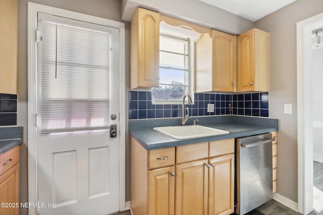 kitchen with dark countertops, decorative backsplash, light brown cabinetry, a sink, and dishwasher