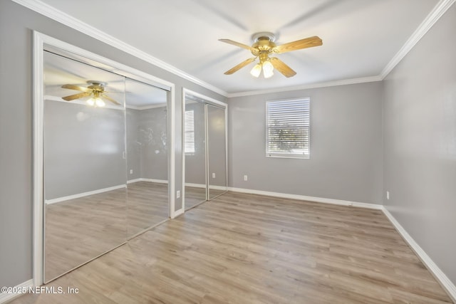 unfurnished bedroom with multiple closets, crown molding, light wood-style flooring, and baseboards