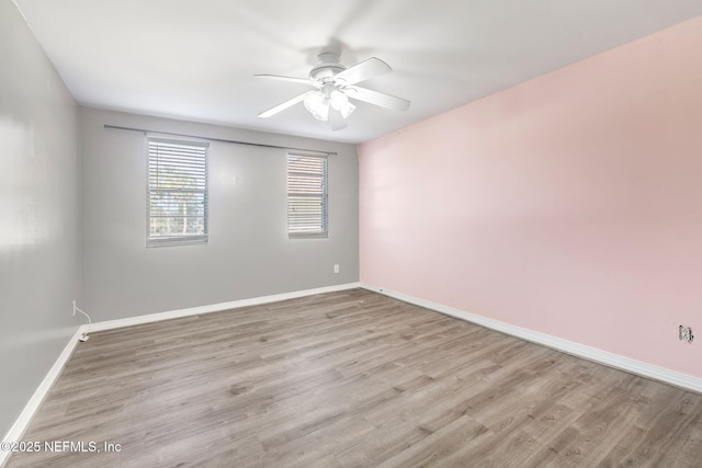 unfurnished room with a ceiling fan, light wood-type flooring, and baseboards