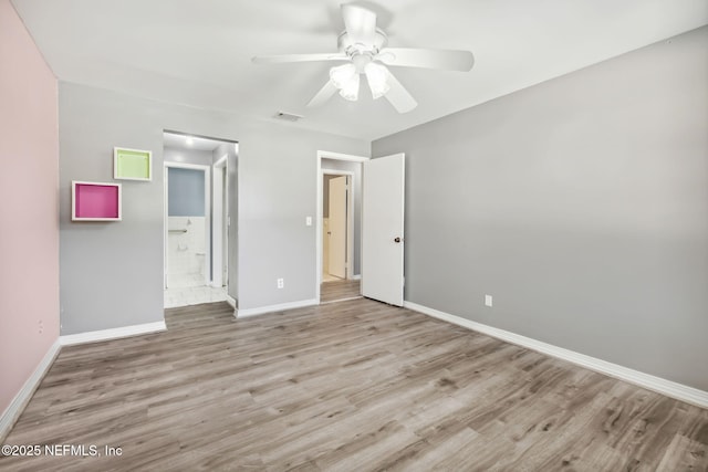 unfurnished bedroom with visible vents, light wood-style floors, a ceiling fan, ensuite bath, and baseboards