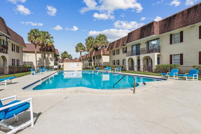 pool featuring a residential view, fence, and a patio